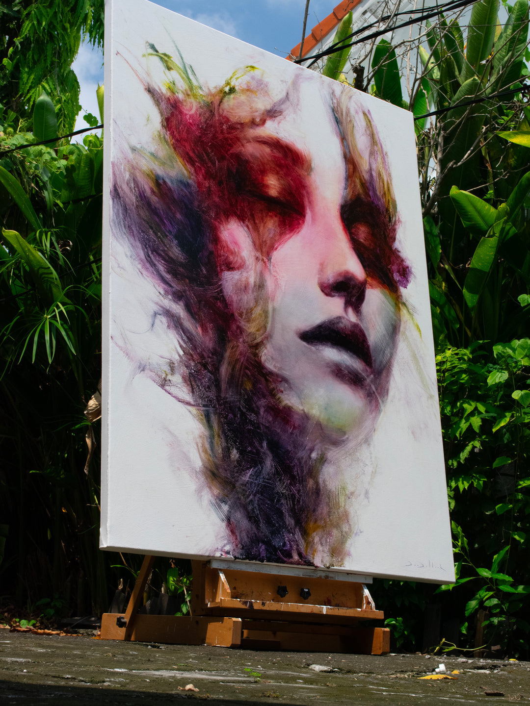 Large oil on canvas portrait by Dan Bullock, titled Spectrum. A dreamlike female face with eyes closed, surrounded by expressive swirls of crimson, violet, emerald, gold, and deep shadow tones, blending realism with abstraction.