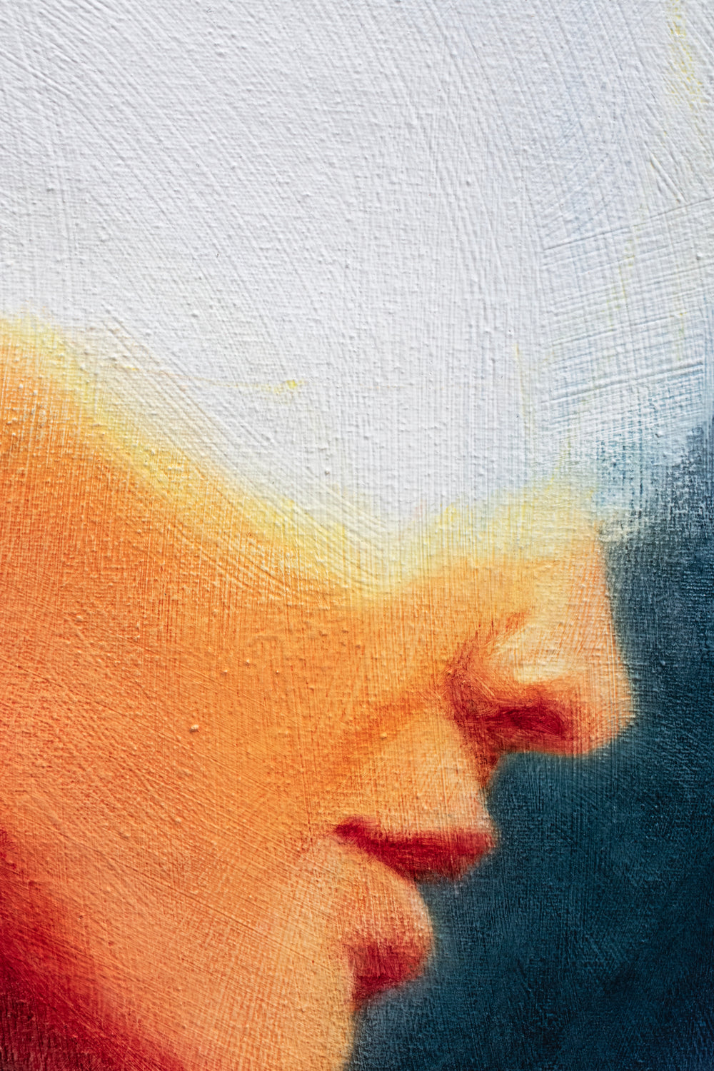 Oil on canvas painting by Dan Bullock, titled Spellbound. A semi-abstract portrait of a woman in profile, her face softly lit in warm peach and orange tones, contrasted against deep navy and indigo brushwork. The upper head dissolves into white light, creating a sense of mystery and transcendence. The expressive textures and layered brushstrokes convey both fragility and strength.