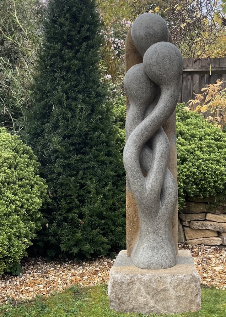 Sporangia by Martin Cash — a one-off stone sculpture carved from a single block of blue and buff Ancaster Weatherbed. The intertwined organic forms rise gracefully from an Ancaster plinth, symbolising unity and growth, designed as a contemporary statement for gardens or public spaces.
