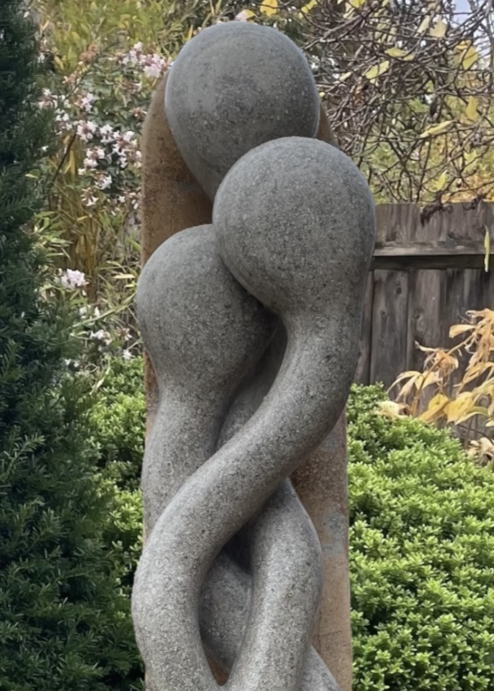 Sporangia by Martin Cash — a one-off stone sculpture carved from a single block of blue and buff Ancaster Weatherbed. The intertwined organic forms rise gracefully from an Ancaster plinth, symbolising unity and growth, designed as a contemporary statement for gardens or public spaces.