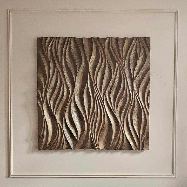 Hand-carved wooden wall panel with flowing, organic wave patterns in natural wood tones.
