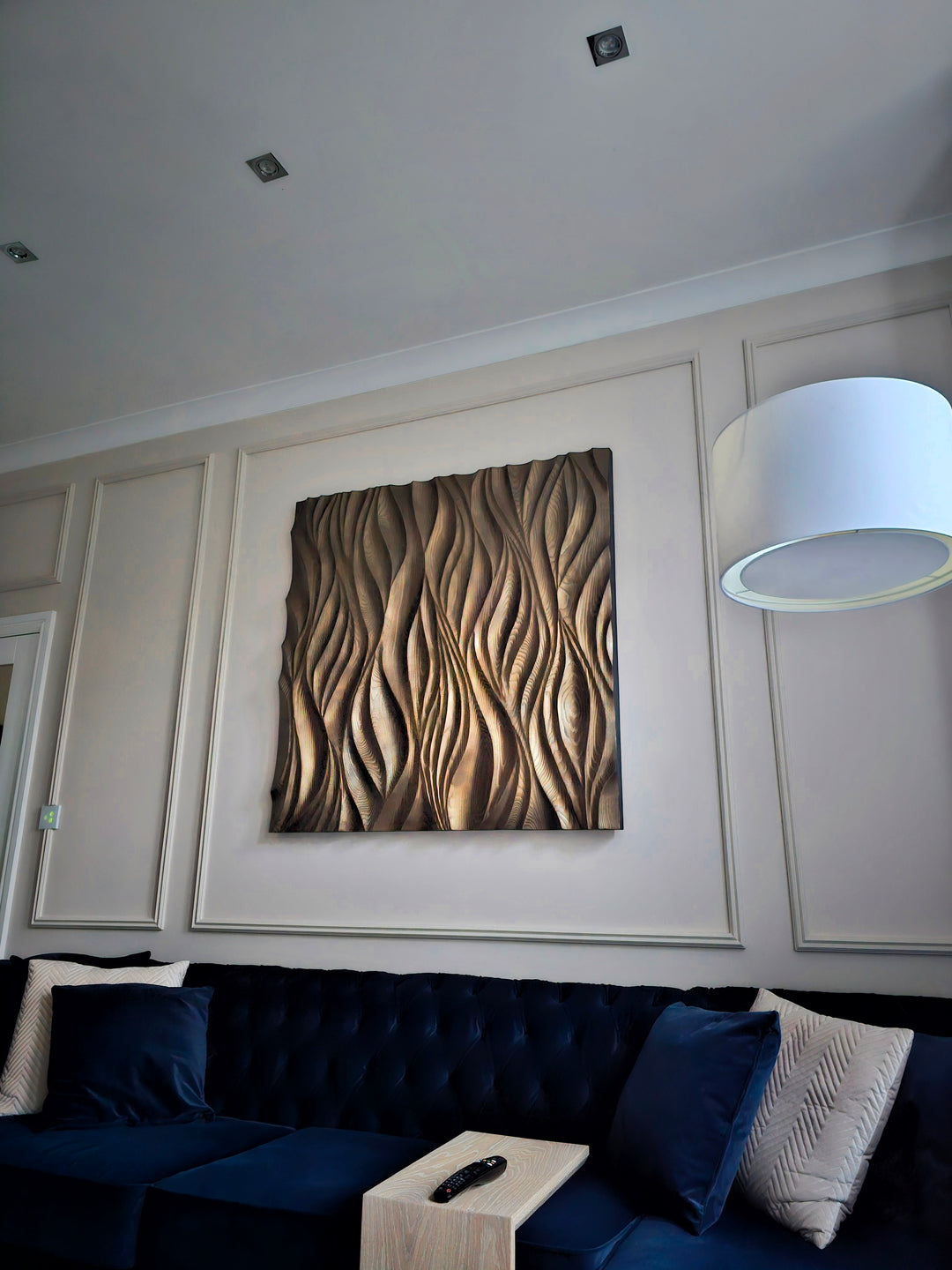 Hand-carved wooden wall panel with flowing, organic wave patterns in natural wood tones.
