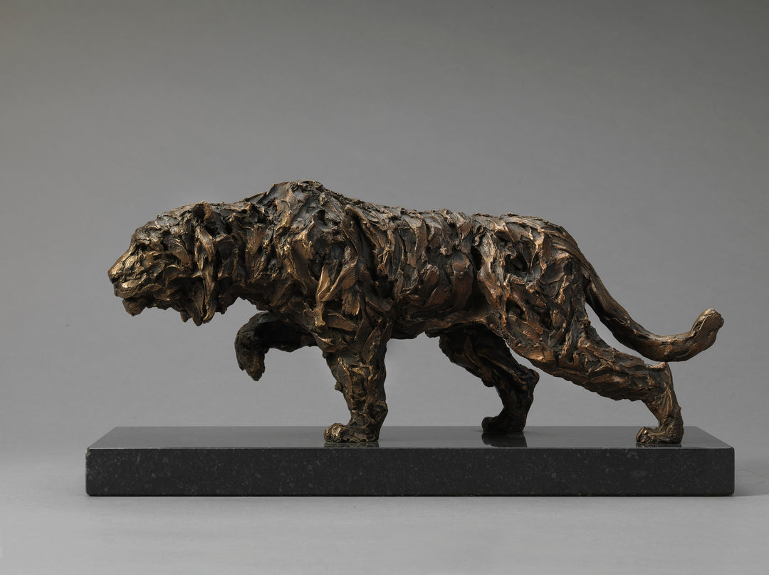Bronze sculpture of a stalking tiger with heavily textured, abstract surface detail, mounted on a dark rectangular base