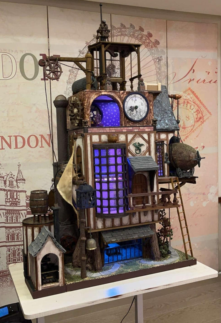 Illuminated steampunk-style dolls house with gears, dials, glowing purple windows, and intricate handcrafted architectural details.