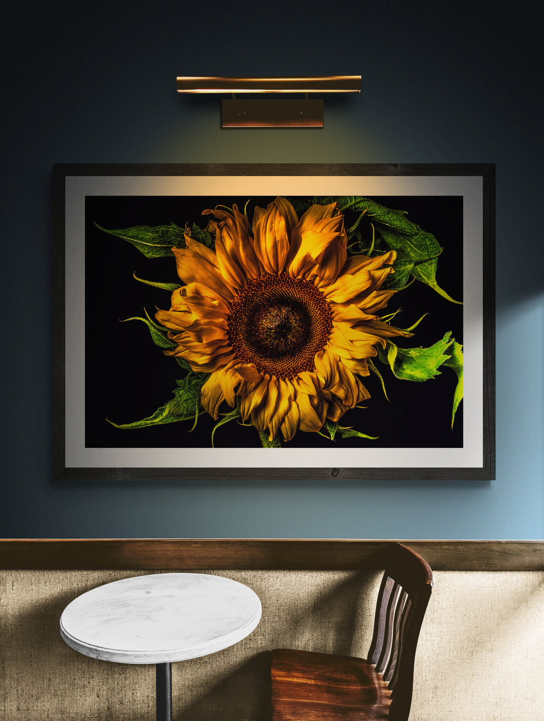 Vivid close-up of a sunflower with golden yellow petals and lush green leaves set against a dramatic black background.