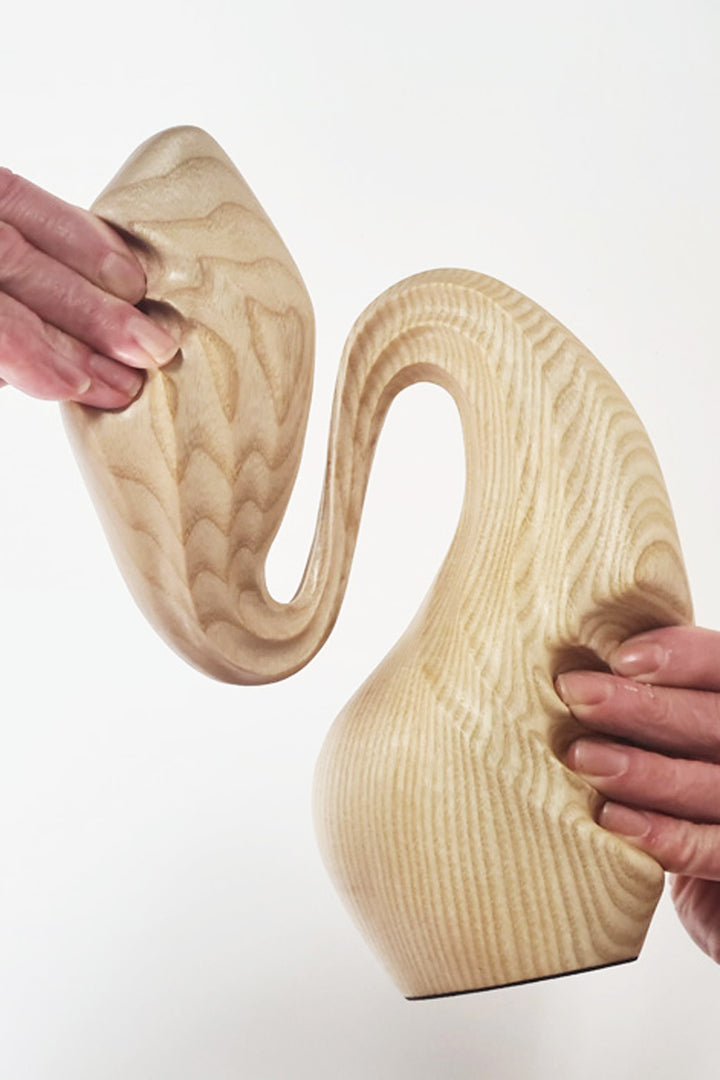 Hand-carved ash wood abstract sculpture with elongated, folded organic forms inspired by stretched sculpting wax and natural movement.