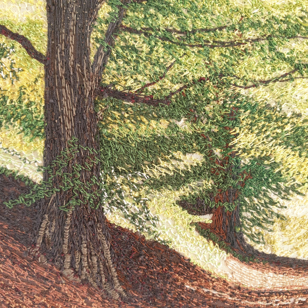 Intricately embroidered woodland scene with sunlit trees and a winding path through a leafy forest.

