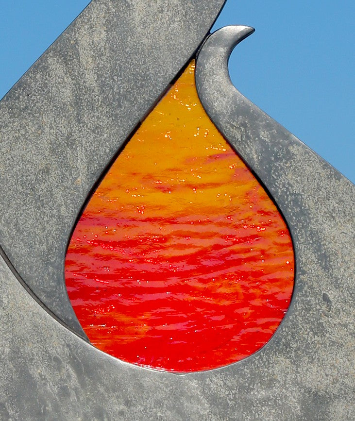 Stacey Beaumont Sunstone slate and glass sculpture, a flame-like form in reclaimed Delabole slate with textured orange and red glass centre inspired by Atlantic sunsets.