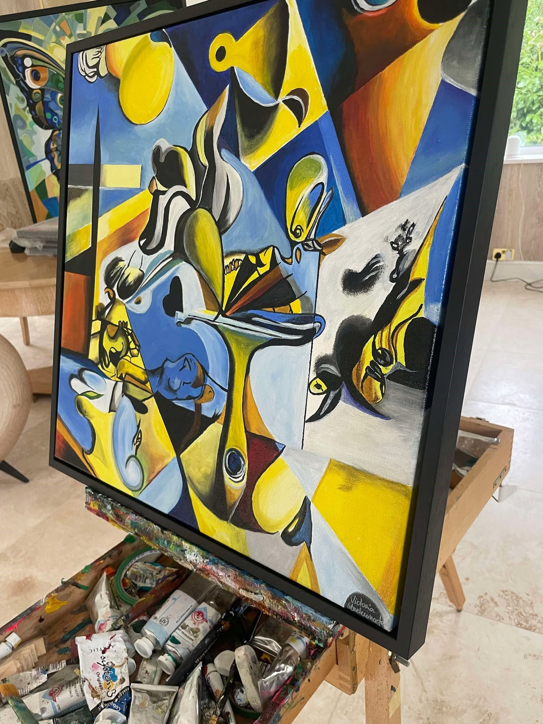 Abstract surrealist painting with bold blue, yellow, and black shapes, featuring distorted figures and dreamlike forms.