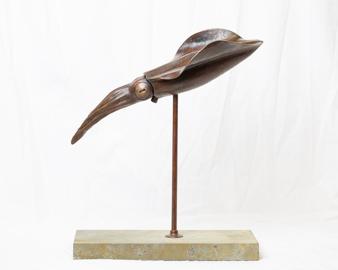 Bigfin Reef Squid bronze sculpture by Tom Saxton mounted on a vertical stand and Cotswold stone plinth, elegant marine life sculpture with flowing fins in rich dark bronze and warm copper-brown tones with subtle golden highlights