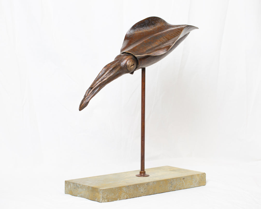 Bigfin Reef Squid bronze sculpture by Tom Saxton mounted on a vertical stand and Cotswold stone plinth, elegant marine life sculpture with flowing fins in rich dark bronze and warm copper-brown tones with subtle golden highlights