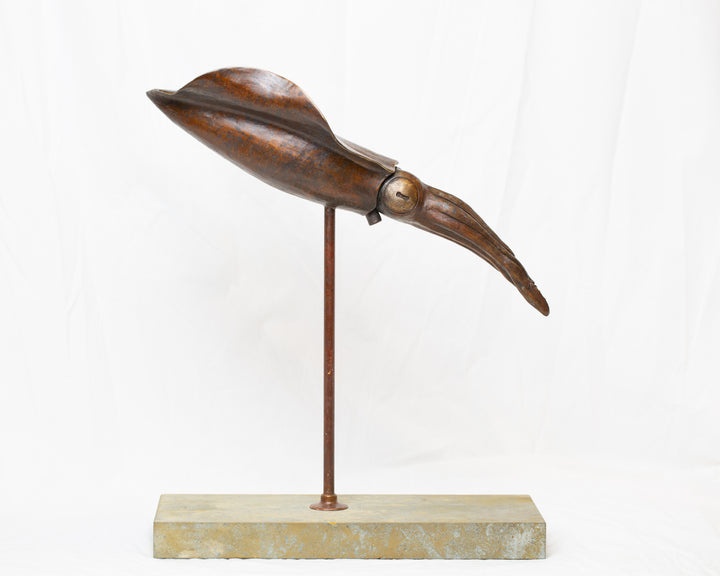 Bigfin Reef Squid bronze sculpture by Tom Saxton mounted on a vertical stand and Cotswold stone plinth, elegant marine life sculpture with flowing fins in rich dark bronze and warm copper-brown tones with subtle golden highlights