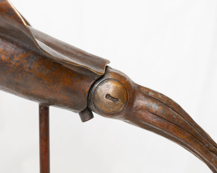 Bigfin Reef Squid bronze sculpture by Tom Saxton mounted on a vertical stand and Cotswold stone plinth, elegant marine life sculpture with flowing fins in rich dark bronze and warm copper-brown tones with subtle golden highlights