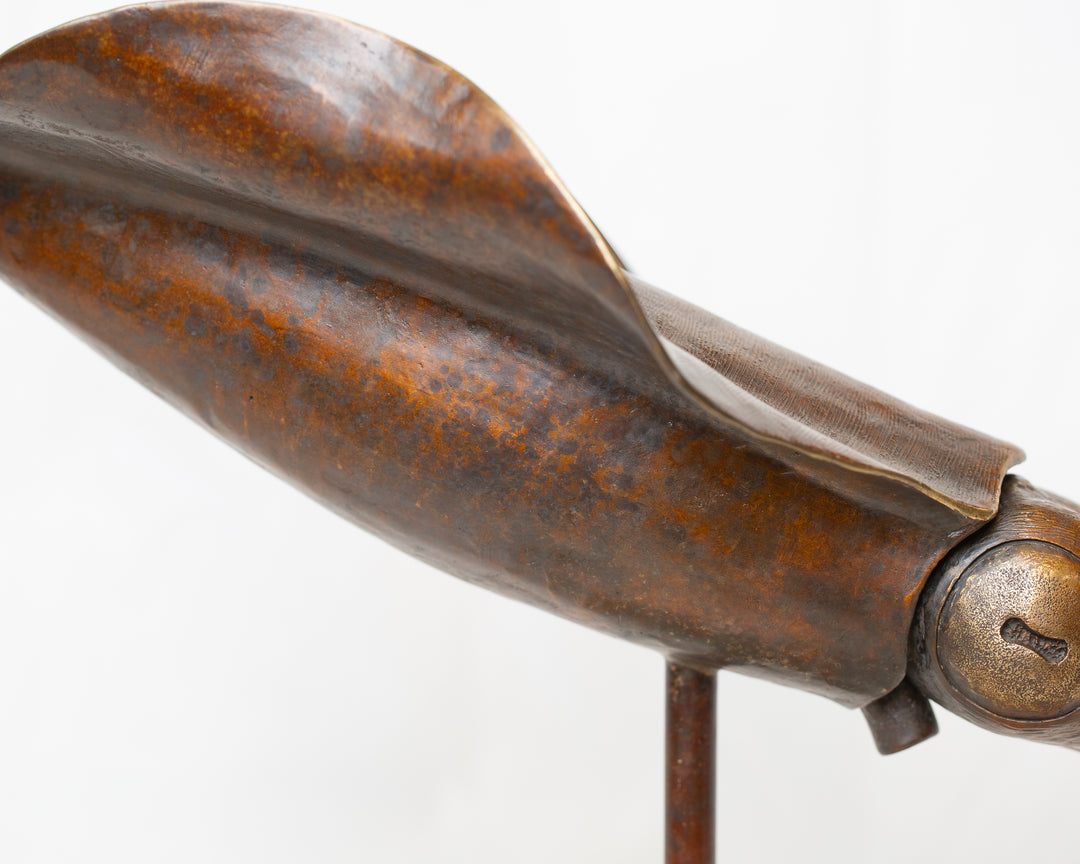 Bigfin Reef Squid bronze sculpture by Tom Saxton mounted on a vertical stand and Cotswold stone plinth, elegant marine life sculpture with flowing fins in rich dark bronze and warm copper-brown tones with subtle golden highlights