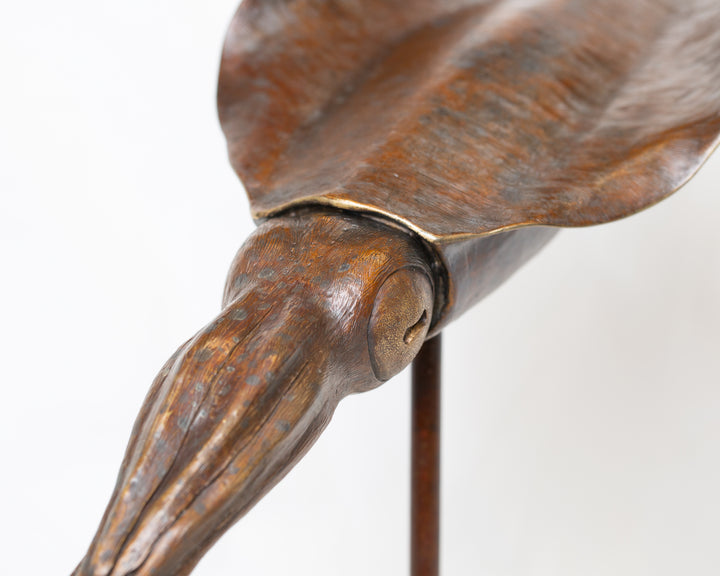 Bigfin Reef Squid bronze sculpture by Tom Saxton mounted on a vertical stand and Cotswold stone plinth, elegant marine life sculpture with flowing fins in rich dark bronze and warm copper-brown tones with subtle golden highlights