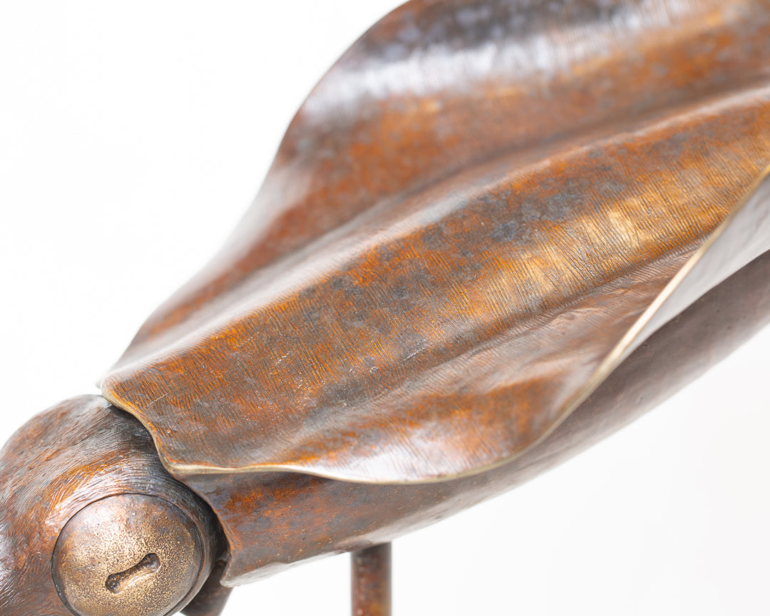 Bigfin Reef Squid bronze sculpture by Tom Saxton mounted on a vertical stand and Cotswold stone plinth, elegant marine life sculpture with flowing fins in rich dark bronze and warm copper-brown tones with subtle golden highlights