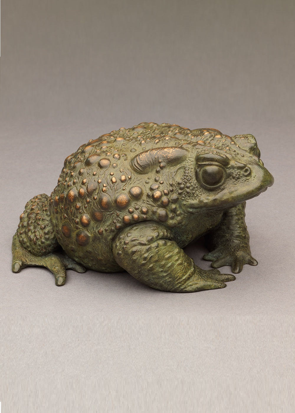 Nick Bibby bronze sculpture of a small toad in a seated, alert posture, detailed textured skin with raised bumps and a natural green–bronze patina.