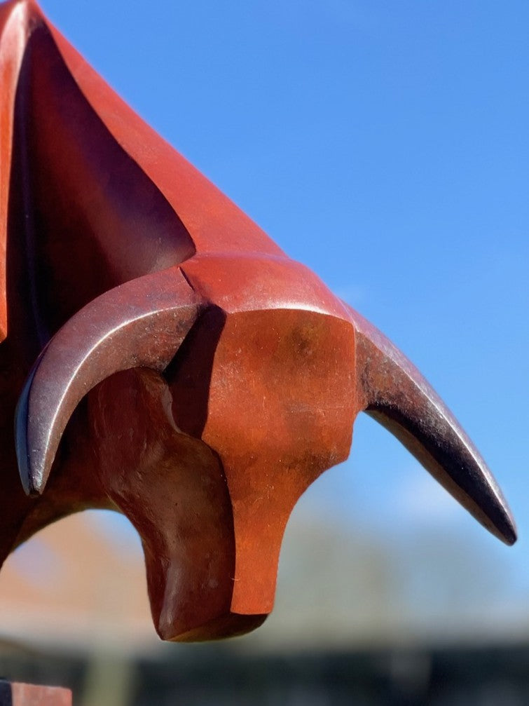 Marie Ackers The Bull’s Head bronze sculpture — stylised abstract bull head with powerful downward stance, geometric lines and deep red patina. Signed, numbered, and foundry stamped with certificate of authenticity.
