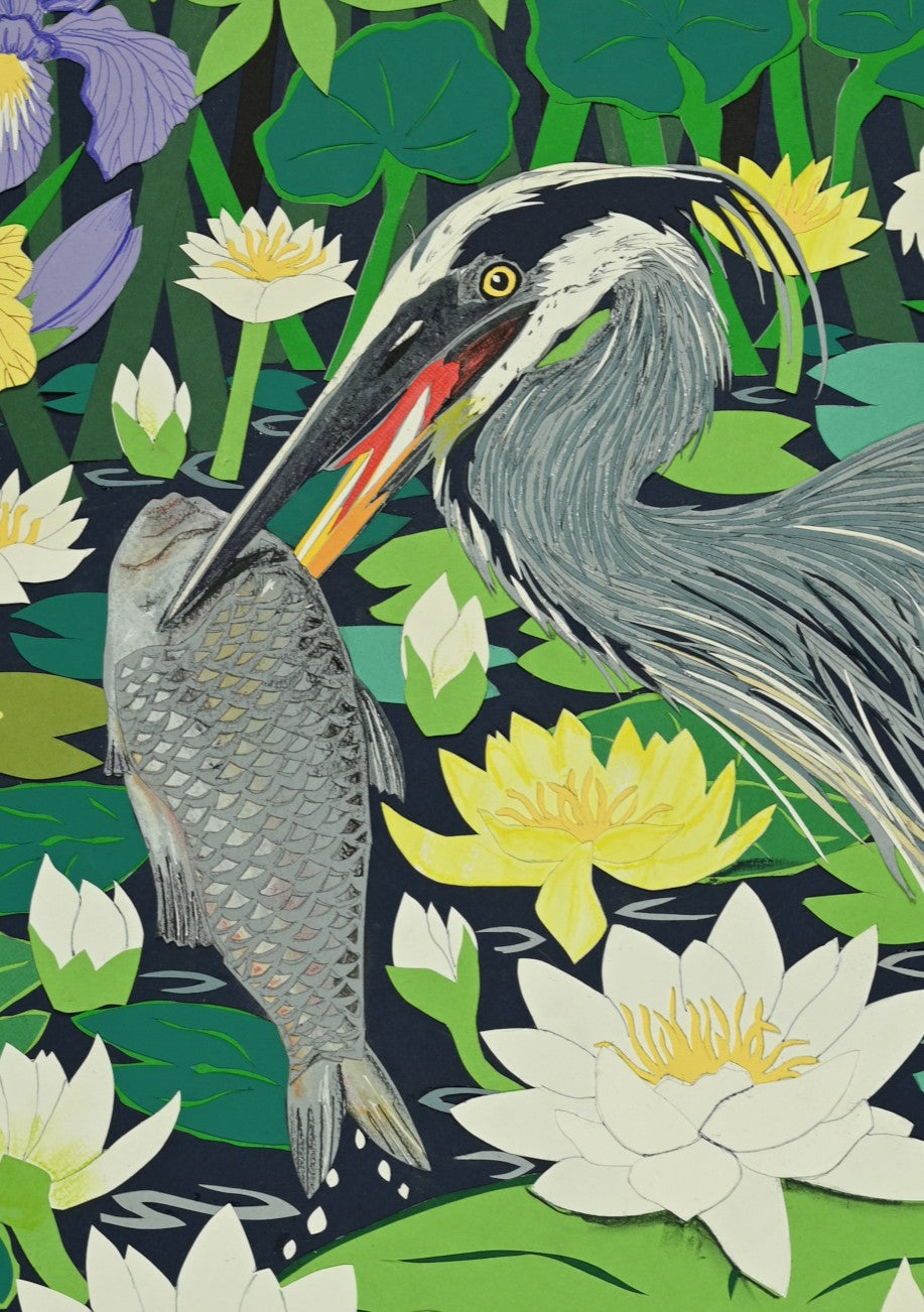 Cut-paper artwork of a heron holding a fish among dense waterlilies, irises and vivid green foliage, with layered coloured papers creating a vibrant pond scene full of movement and detail.