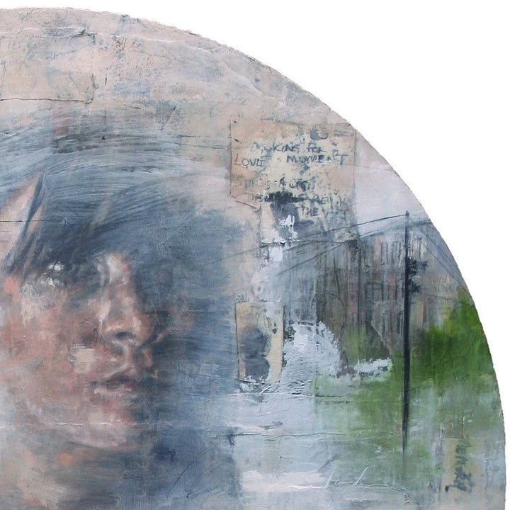 Toni Cogdell’s circular mixed media painting titled The River features a soft, partially obscured female portrait emerging from a wash of pale greys, blues, and greens. Surrounded by subtle architectural sketches, abstract textures, handwritten fragments, and a solitary heron, the piece evokes memory and landscape as one. The composition drifts fluidly between figuration and abstraction, layered with acrylic, spray paint, collage, and oil on wood panel.