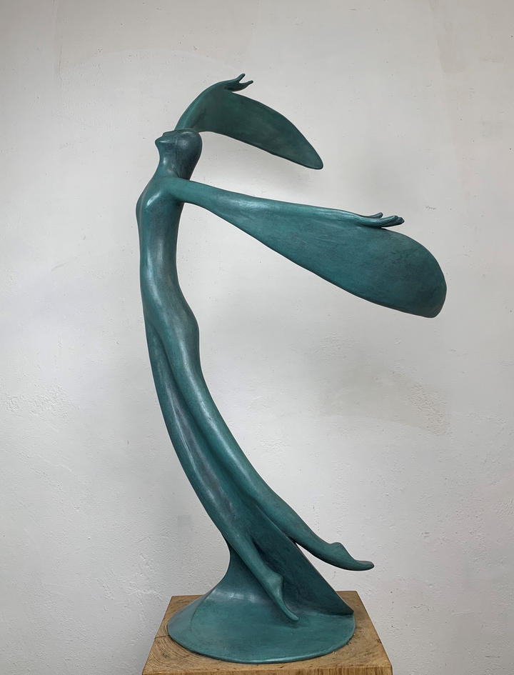 Abstract teal bronze sculpture of a flowing female figure with elongated arms and sweeping wing-like forms, suggesting flight or dance.