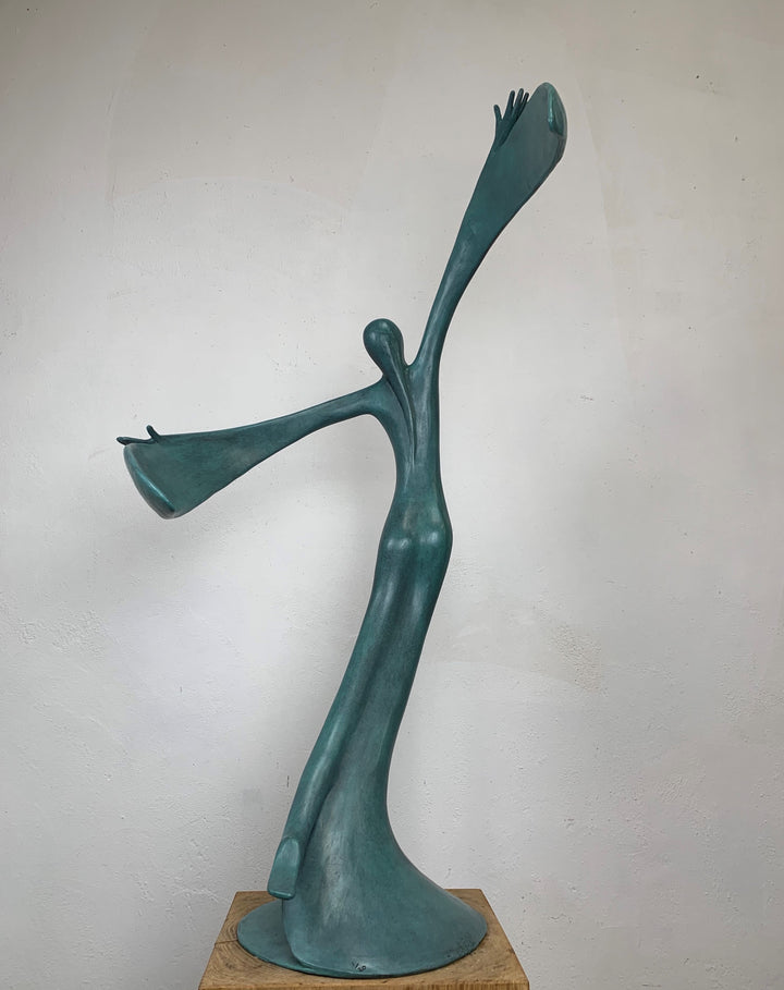 Abstract teal bronze sculpture of a flowing female figure with elongated arms and sweeping wing-like forms, suggesting flight or dance.