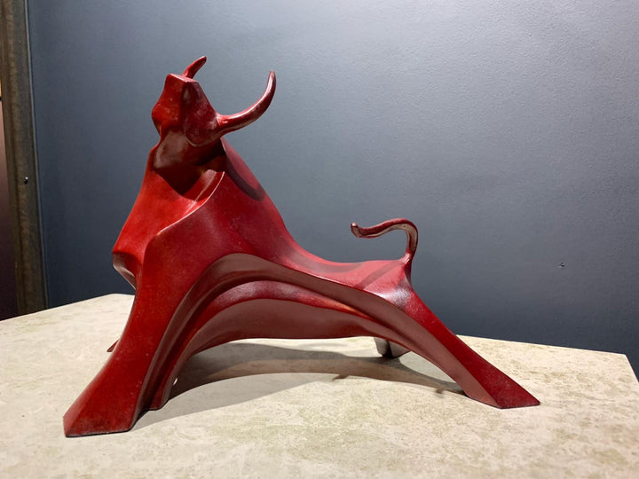 Marie Ackers Small Red Bull bronze sculpture — dynamic, abstract bull with flowing geometric curves and raised horns. Deep red patina. Signed, numbered, and foundry stamped. Scaled version of her Large Red Bull.