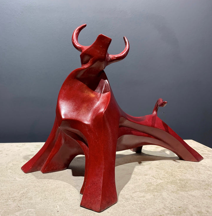 Marie Ackers Small Red Bull bronze sculpture — dynamic, abstract bull with flowing geometric curves and raised horns. Deep red patina. Signed, numbered, and foundry stamped. Scaled version of her Large Red Bull.