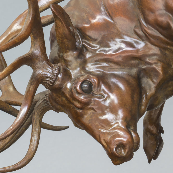 Bronze sculpture of two red deer stags in mid-rut, antlers locked in a dynamic head-to-head clash, highly detailed musculature and patina, mounted on a textured bronze base.
