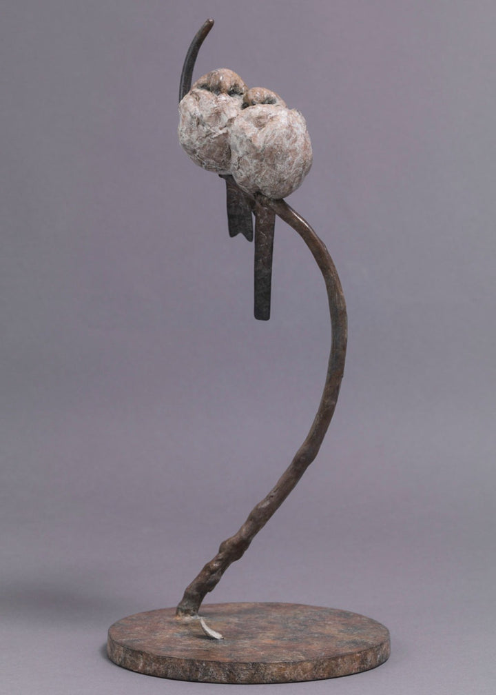 A delicate bronze sculpture of two long-tailed tits nestled together on a sweeping branch, their rounded forms and soft patinated tones capturing warmth, intimacy and the gentle character of these much-loved British birds.
