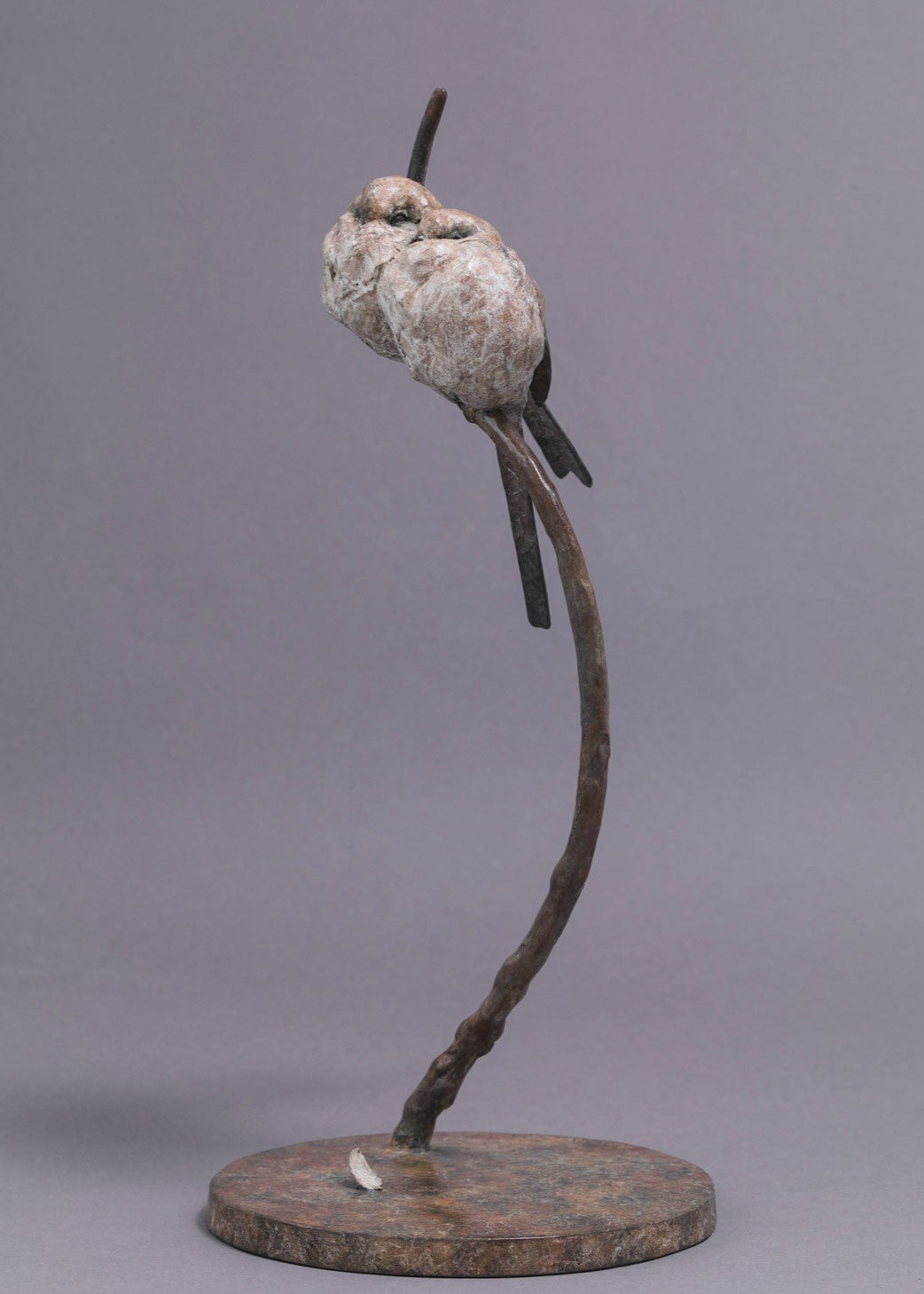 A delicate bronze sculpture of two long-tailed tits nestled together on a sweeping branch, their rounded forms and soft patinated tones capturing warmth, intimacy and the gentle character of these much-loved British birds.