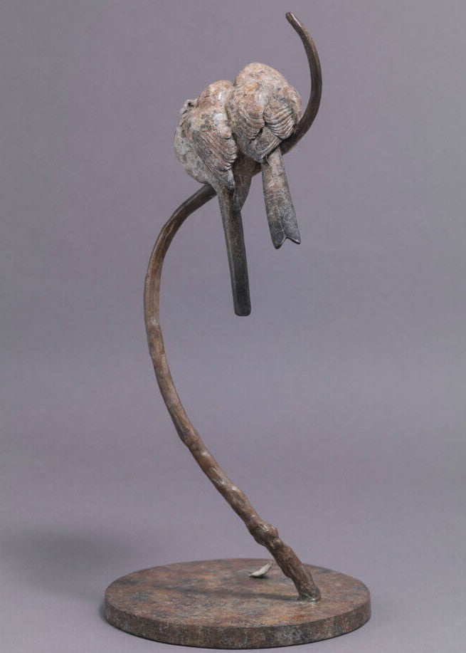 A delicate bronze sculpture of two long-tailed tits nestled together on a sweeping branch, their rounded forms and soft patinated tones capturing warmth, intimacy and the gentle character of these much-loved British birds.