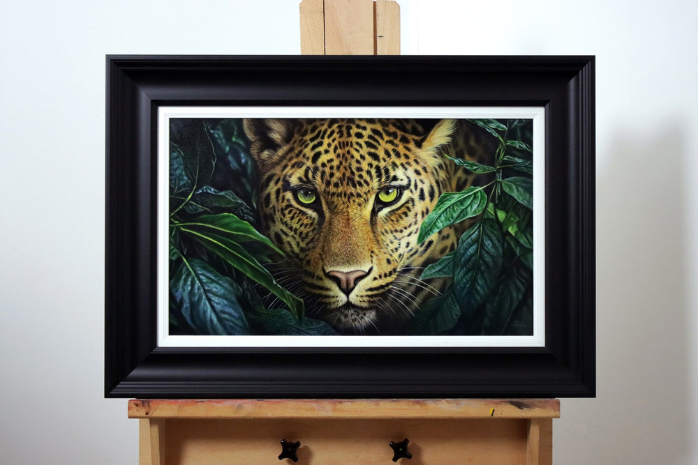 Hyperrealistic painting of a leopard staring through dark green jungle leaves with piercing yellow-green eyes.