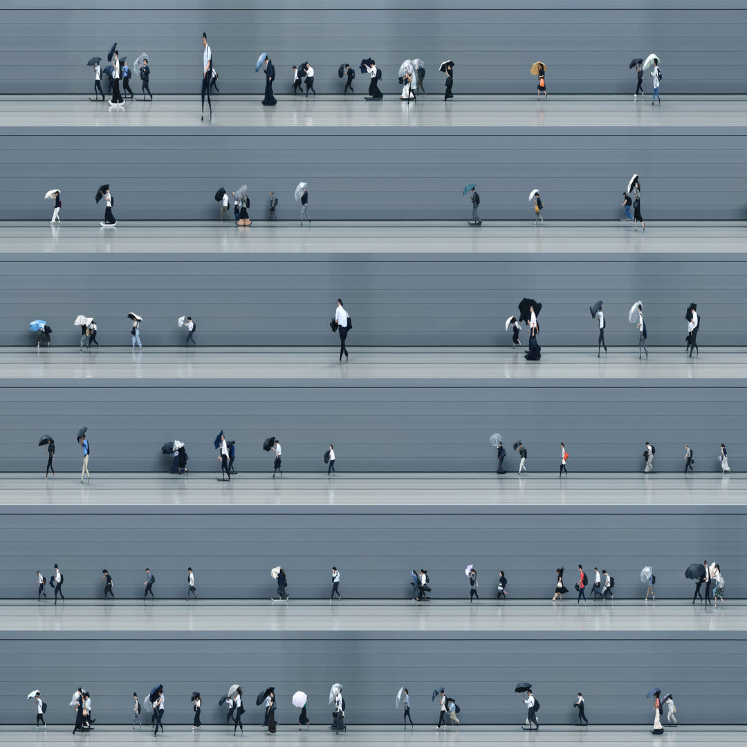 A stylised time-slice image of Tokyo commuters struggling against wind and rain during a summer storm. Each figure holds an umbrella as they move across a smooth, steel-grey background—some distorted mid-stride due to the artist’s high-speed video scan technique. The image captures both the uniformity and individuality of city life under pressure.