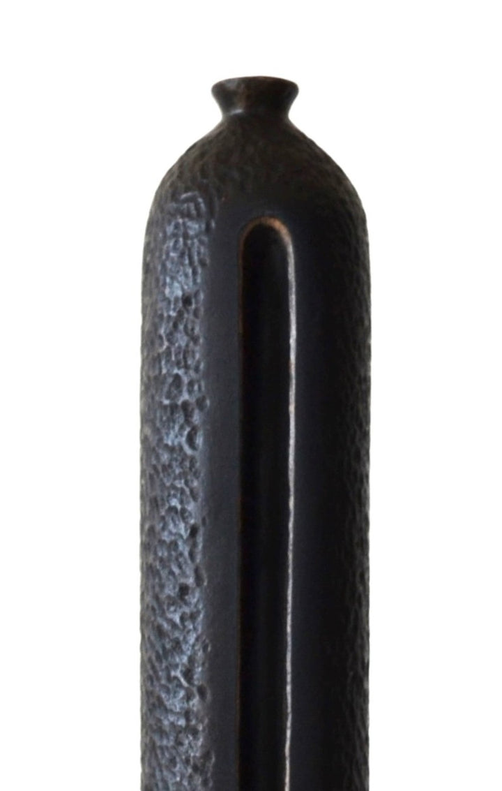 TORR by Nicola Beattie – tall, slender walnut sculpture with textured, rounded form and deep central vertical recess, mounted on a solid stepped base. Rich dark brown finish with natural grain, evoking ancient totems and minimalist modern design.