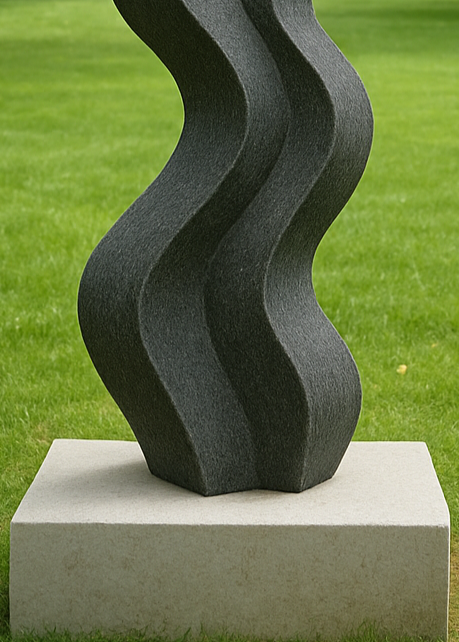 Unity in Motion by Martin Cash — a fluid, abstract sculpture hand-carved from Ancaster Blue Stone and mounted on a Stoke Ground plinth with granite base. The dark, undulating form evokes rhythm and balance, designed as a striking contemporary centrepiece for gardens or public spaces.
