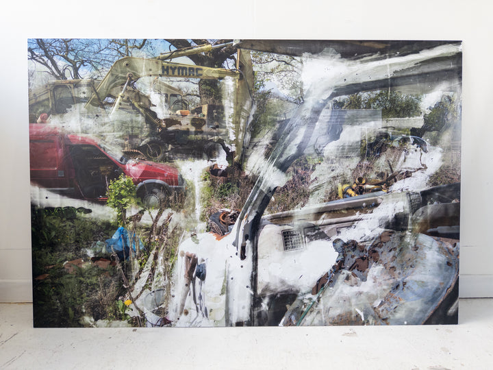 Layered image of a scrapyard scene featuring old vehicles, a red van, a yellow HYMAC digger, overgrown grass, and rusted machinery, with painterly chemical textures and white streaks applied over aluminium.
