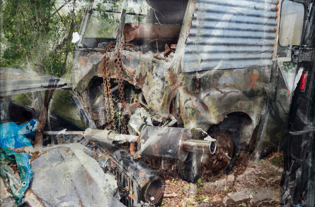 A fragmented, semi-abstract composition of a crumpled van enveloped in rust, chains, and corroded metal, set against a backdrop of overgrown woodland. The surface of the vehicle is a patchwork of peeling paint and oxidised textures, with a twisted exhaust pipe and exposed mechanical parts jutting forward. Faint reflections and layered overlays create a painterly, dreamlike distortion across the entire scene.