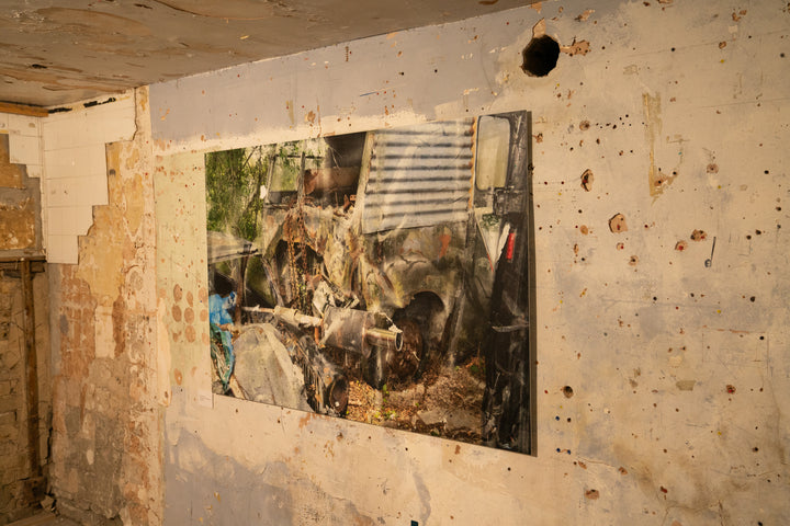 A fragmented, semi-abstract composition of a crumpled van enveloped in rust, chains, and corroded metal, set against a backdrop of overgrown woodland. The surface of the vehicle is a patchwork of peeling paint and oxidised textures, with a twisted exhaust pipe and exposed mechanical parts jutting forward. Faint reflections and layered overlays create a painterly, dreamlike distortion across the entire scene.