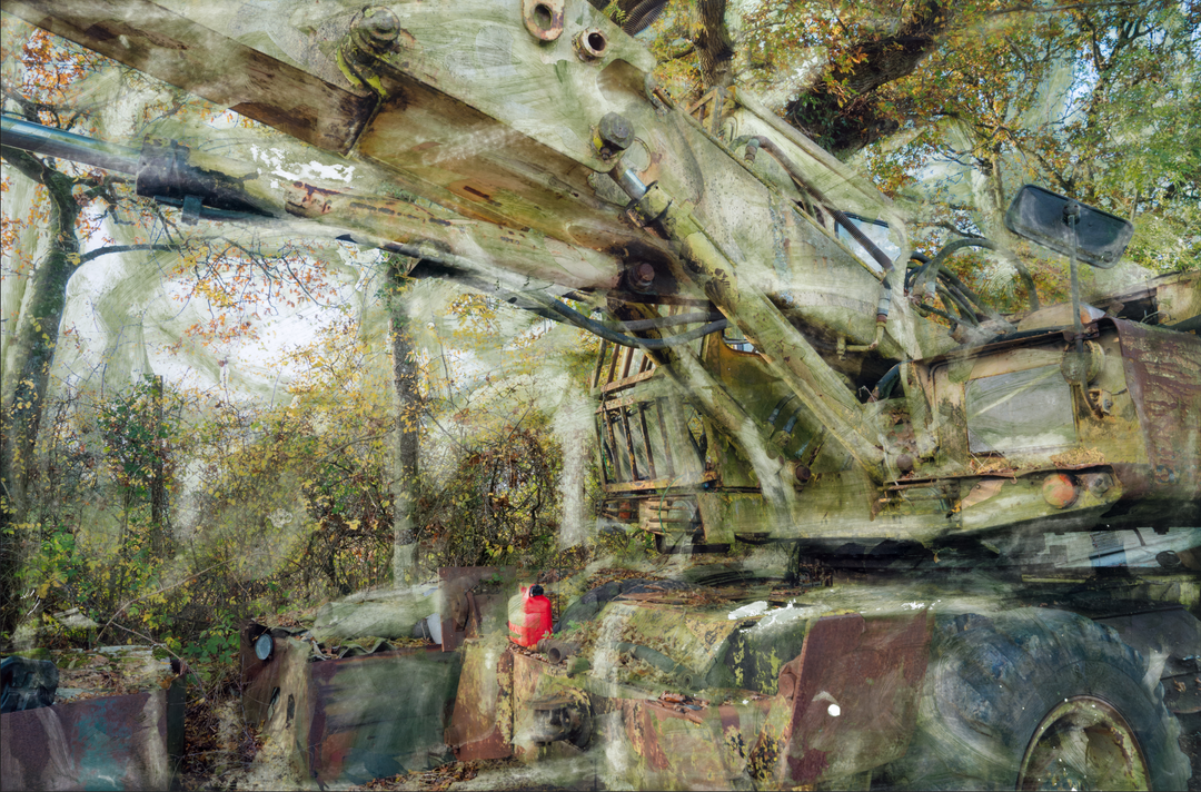 A decaying military-green crane or heavy machinery vehicle sits partially buried in a woodland clearing, its massive hydraulic arms rusted and streaked with oxidised residue. Autumnal foliage surrounds and overlays the scene, while painterly textures and ghosted transparencies give the piece a spectral, timeworn atmosphere. A solitary red fuel container adds a flash of colour against the muted industrial palette.