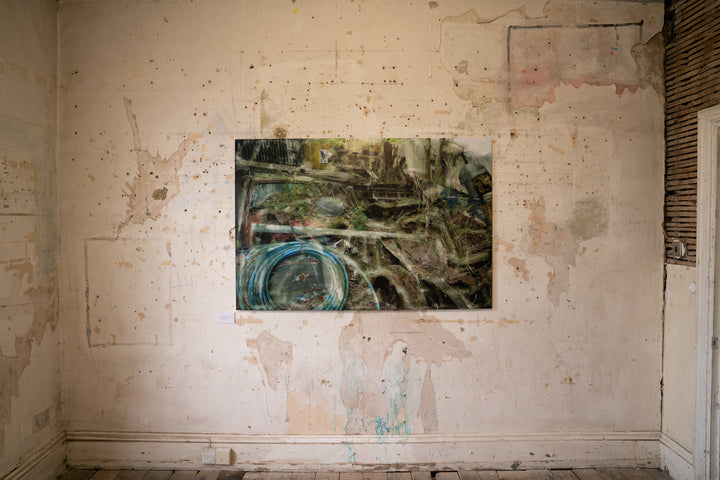 A densely layered, textural composition showing an entangled heap of decaying wood, metal, and automotive debris partially reclaimed by moss and undergrowth. Coiled blue piping, a fragmented red vehicle, and collapsing wooden structures are enveloped by soft overlays and distressed surfaces. The entire scene feels submerged in a dreamlike mist of erosion, time, and industrial memory.