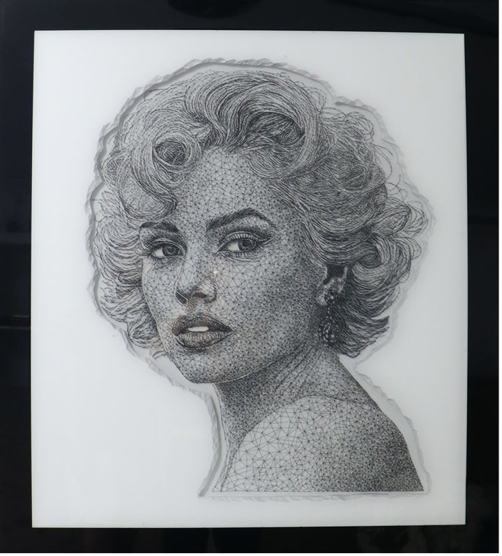 Portrait of a glamorous woman created with intricate black string threaded through thousands of tiny nails, forming detailed facial features and hair on a white panel.
