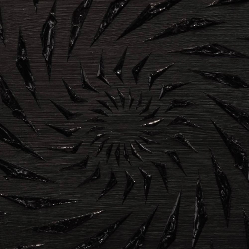 Black-on-black contemporary wall artwork by Mike Philp with angular geometric forms spiralling inward across a dark ground. Subtle texture and shadow create depth, movement, and quiet intensity.