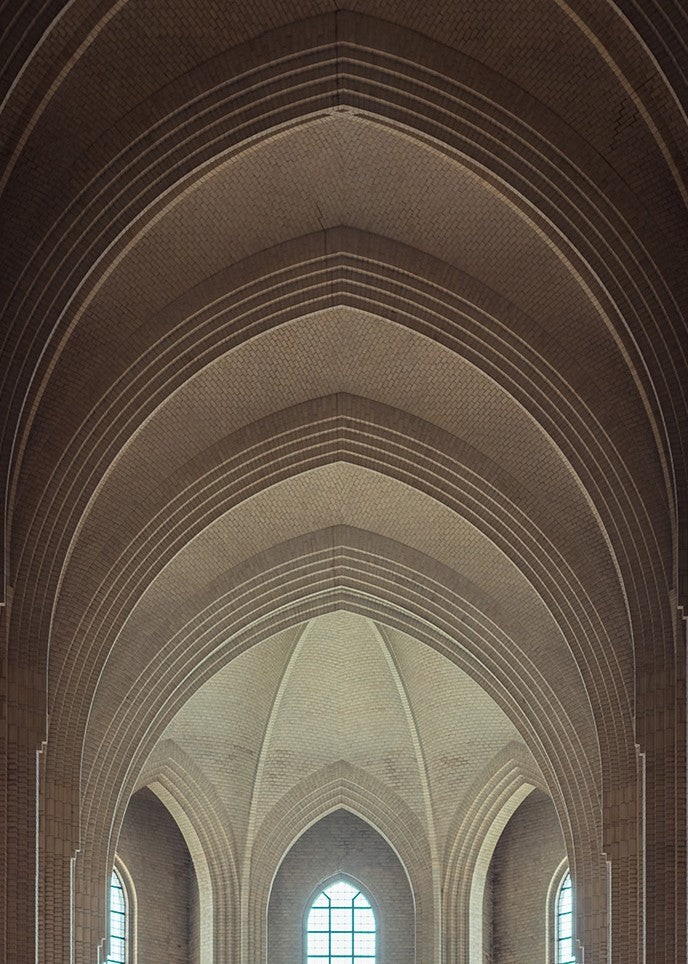 Panoramic photograph of Grundtvigs Kirke interior, showing soaring brick arches, vertical symmetry, tall windows and glowing light, capturing the calm geometry and spiritual presence of Danish Brick Expressionism.