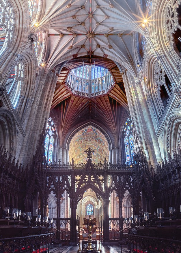Panoramic photograph of Ely Cathedral interior, showing the soaring nave, intricate fan vaulting, and dramatic symmetry, blending Romanesque and Norman architecture with light, colour, and choral presence.