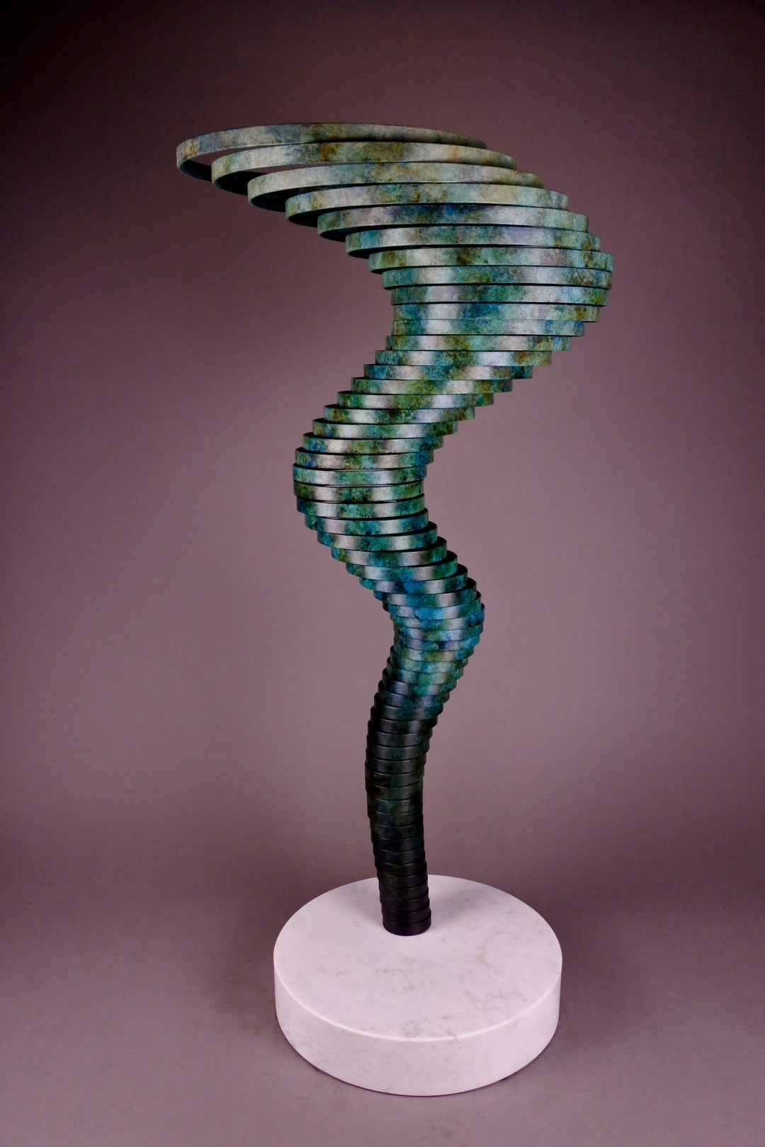 Vortex II by Thomas Joynes – a limited edition bronze sculpture with artisan patina, exploring Fibonacci-based forms through stacked, spiralling discs. The rich verdigris patina in green-blue and rust tones highlights the rhythmic, wave-like movement of the bronze layers. Mounted on a smooth Carrara marble base, the piece brings a sense of elegance and kinetic energy to any contemporary interior.