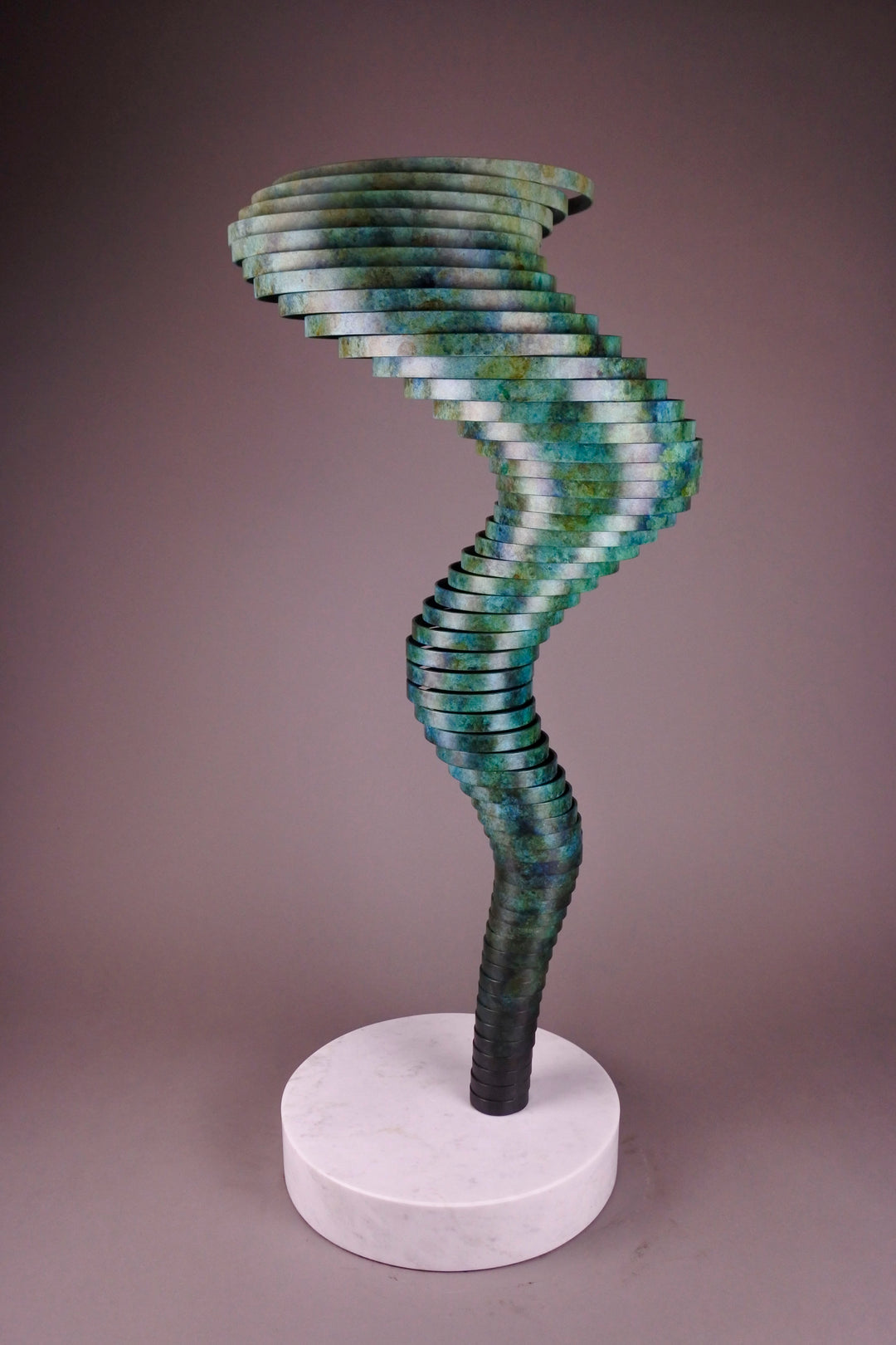 Vortex II by Thomas Joynes – a limited edition bronze sculpture with artisan patina, exploring Fibonacci-based forms through stacked, spiralling discs. The rich verdigris patina in green-blue and rust tones highlights the rhythmic, wave-like movement of the bronze layers. Mounted on a smooth Carrara marble base, the piece brings a sense of elegance and kinetic energy to any contemporary interior.