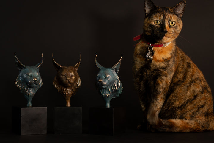 Wee Petra Eurasian Lynx bronze sculpture by Min Reed, miniature lynx head with closed eyes and elegant ear tufts in green verdigris bronze with warm copper highlights, mounted on a small black plinth, contemporary wildlife bronze sculpture