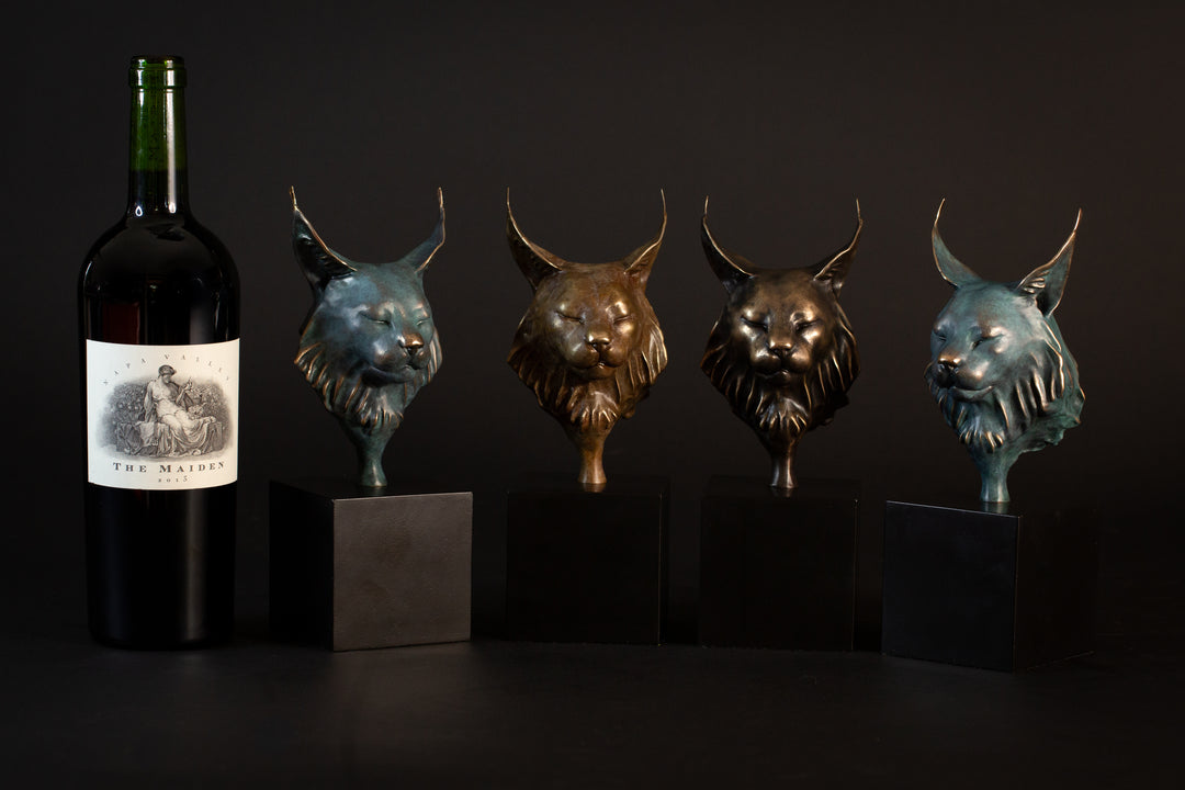 Wee Petra Eurasian Lynx bronze sculpture by Min Reed, miniature lynx head with closed eyes and elegant ear tufts in green verdigris bronze with warm copper highlights, mounted on a small black plinth, contemporary wildlife bronze sculpture