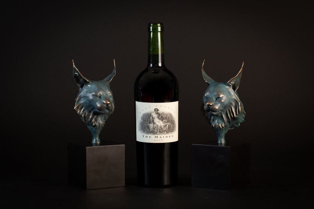 Wee Petra Eurasian Lynx bronze sculpture by Min Reed, miniature lynx head with closed eyes and elegant ear tufts in green verdigris bronze with warm copper highlights, mounted on a small black plinth, contemporary wildlife bronze sculpture